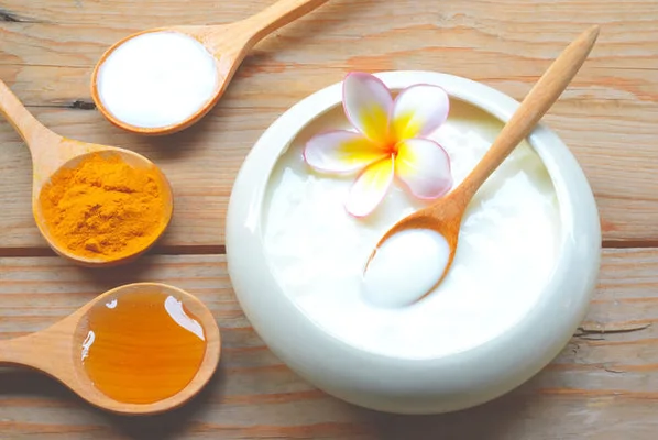 Qué comer para aliviar la hinchazón abdominal Una selección de alimentos recomendados sobre qué comer cuando tienes hinchazón abdominal, incluyendo una taza de té de jengibre, papaya y un bol de yogur.