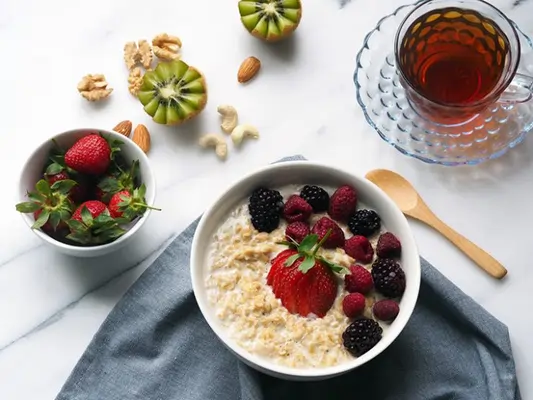Alimentos que explican qué es la fibra y para qué sirve Un bol lleno de alimentos ricos en fibra como avena, bayas y nueces, explicando qué es la fibra y para qué sirve en una dieta saludable.