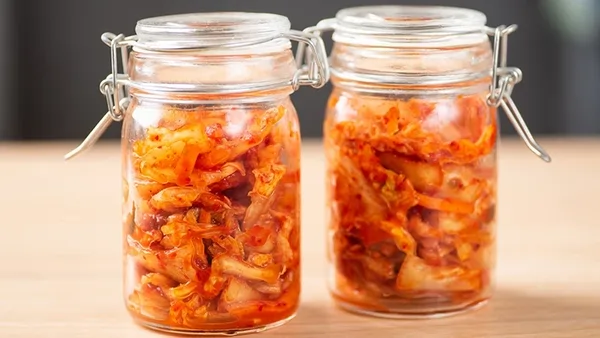 Ejemplos de una dieta de alimentos fermentados Varios frascos con alimentos como chucrut y kimchi, explicando qué es una dieta de alimentos fermentados y sus beneficios.